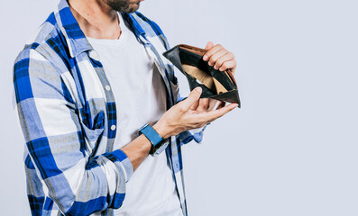 Moneyless frustrated person concept. Sad man showing an empty wallet, Sad person showing an empty...