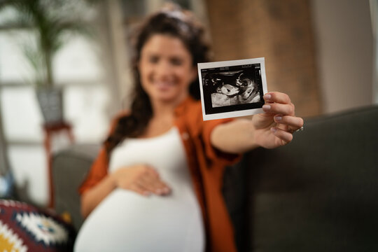  Pregnant woman with ultrasound photo. Beautiful pregnant woman enjoy at home
