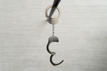 concept of arrest of unfreedom or sexual role-playing games of bdsm. Handcuffs hanging on black...