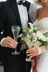 Wedding party, bride and groom drinking champagne, close-up hands