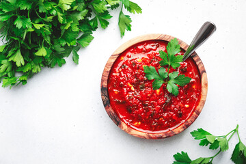 Traditional spicy arrabiata sauce with hot red peppers, garlic and herbs on white kitchen table...