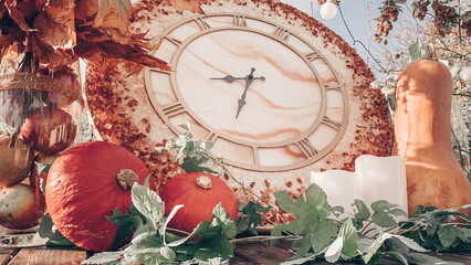 Autumn garden home decoration composition with clock, pumkins, candles and apples. Fall yard arrangement on the table or other zone