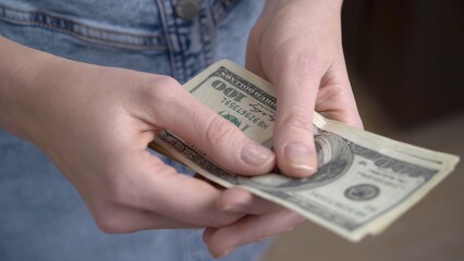 Close-up of female hands counting dollars