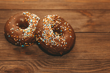 Round-shaped donuts with chocolate glaze and colored sprinkles.