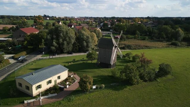 Restored wooden structure. Spectacular aerial view flight speed ramp Hyperlapse motionlapse
of a old Wooden Trestle windmill in brandenburg Germany at summer golden hour 2022. 4k marnitz Cinematic