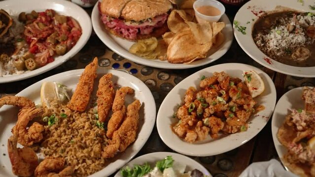 Variety of cajun creole comfort food dishes, tabletop filled with savory soul food options, slider 4K
