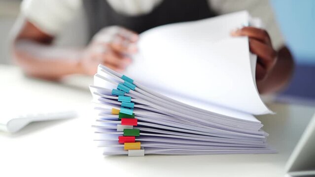 Clerk With Stacked Tax Files And Documents