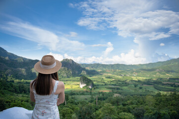 Fototapeta premium Asian woman traveler relaxing and watching a beautiful mountain view with nature in the morning, Phu Langka National Park, Thailand