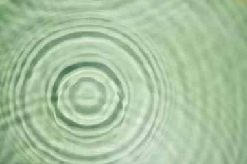 Defocused rippled transparent green water gel with concentric expanding circles on surface from fallen drop with waves © Евгения Рубцова