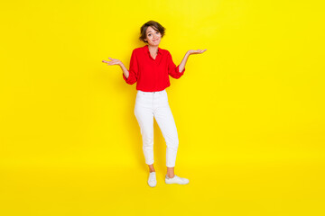 Full size portrait of questioned positive girl hands shrug shoulders not know isolated on yellow color background