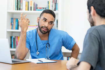 Serious young hispanic doctor or nurse talking with patient