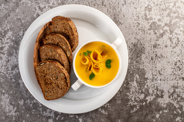 Fresh and healthy pumpkin cream soup with herbs. Vegan cuisine