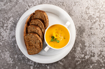 Fresh and healthy pumpkin cream soup with herbs. Vegan cuisine