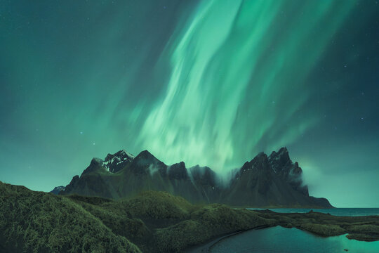 Scenic View Of Snowy Mountains And Lake Under Sky With Polar Light