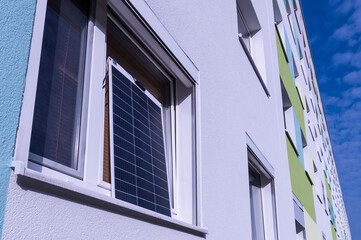 Mieter einer Wohnung stellen sich Solarpanele ans Fenster um die steigenden Stromkosten zu senken 