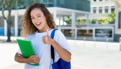 Successful german female student with backpack and paperwork