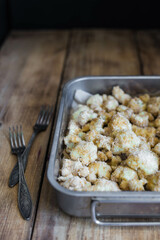 Breaded cauliflower on a wooden table, dark background, close-up, top view, selective focus, no people.