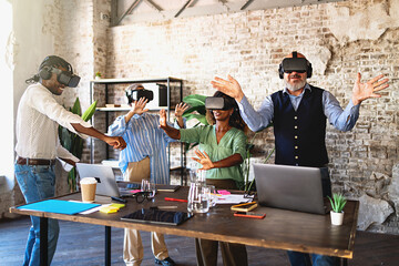 Group of coworkers testing a project in metaverse virtual reality wearing 3d googles and having fun together