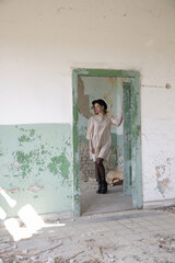 Serie of photos of female model in beige dress in the abandoned ruined building