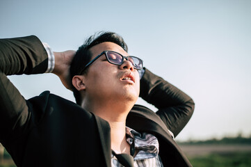 Asian Businessman tired and sleeping for relaxing at outdoors