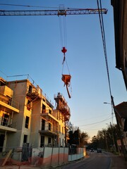 Immeuble d'habitation en travaux de construction avec grue de chantier en mouvement 