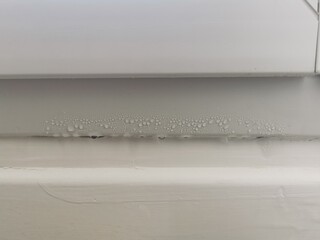 Goutte d'eau de condensation sur le bas d'un fenêtre en PVC
