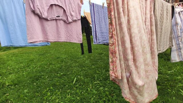 Different clean clothes drying after washing on the rope outdoors. 