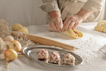 Women’s hands, flour and dough. A woman is preparing a dough for home baking. Concept of home cooking with organic and natural ingredients. Zero waste concept