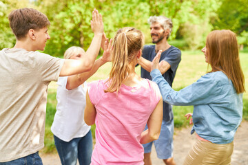 Young people stand in a circle giving a high five