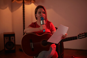 Obraz premium Woman playing music and singing on a wireless microphone in a retro vintage room.