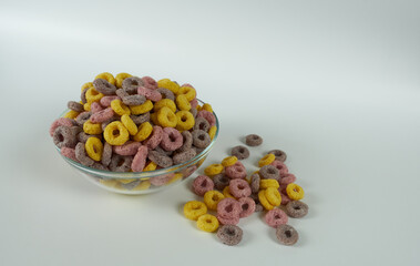Cornflakes rings in a glass plate on a white background, close-up. 