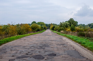 Empty asphalt road with rural autumn landscape. Broken asphalt road.
