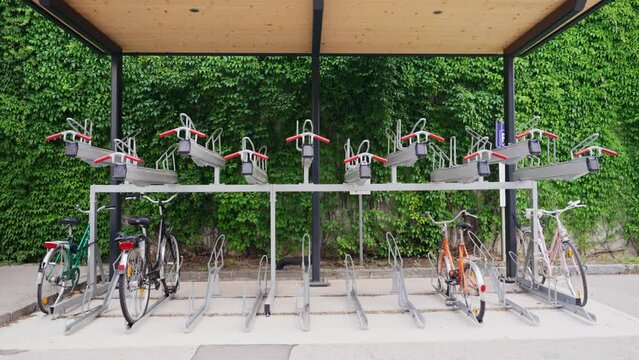 Bicycle rack for storage and parking in the city or next to train station. Bikes parked and tied to a special rack for commuters installed in transit stations of railways and subways. Green commute