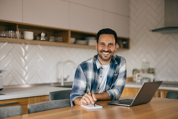 Portrait of an adult man, looking at the camera, smiling, and planning something for work.