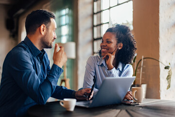 Smiling African woman looking at her male client, having a meeting.