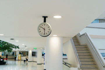The clock hangs on the wall of the office building.