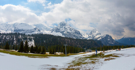 Scenic view of snow capped mountain peaks of Karawanks from Sinacher Gupf in Carinthia, Austria. Mount Hochstuhl (Stol) is visible through dense forest in early spring. Rosental on sunny day. Freedom
