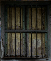 old and classic wooden window with rusty iron grill