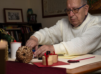 An elderly man opens a bottle of ink to do calligraphy by hand