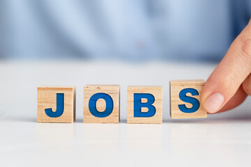 Businesswoman placing wooden blocks on the white table, "Jobs" concept.
