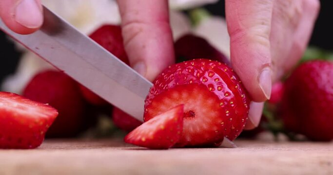 Cut into pieces ripe red strawberries, red strawberries are divided into slices for dessert