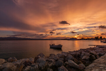 Fototapeta na wymiar Krajobraz morski. Widok z zachodem słońca i łódkami na morzu na greckiej wyspie Evia. Wieczorne scenerie z pięknym niebem w tle. 