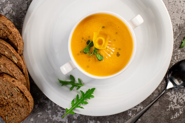 Fresh and healthy pumpkin cream soup with herbs. Vegan cuisine