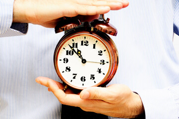 man in shirt and tie holding an alarm clock