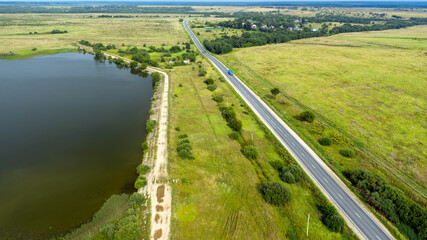 Top view of a motor road along the lake on a summer day