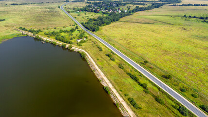 Top view of a motor road along the lake on a summer day