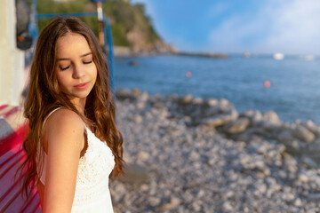 Fototapeta na wymiar Young girl enjoys the sunshine on the seashore