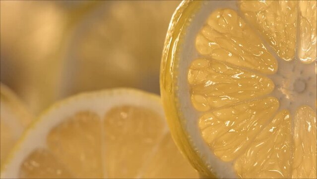 Drop of Lemon Juice flow down the surface of a ripe juicy Lemon slice. Slow Motion 4K