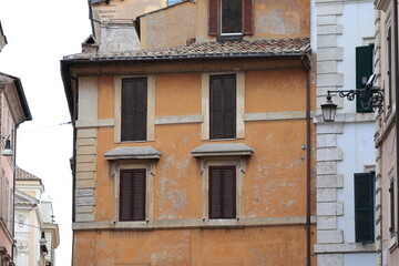 Fototapeta na wymiar Rome Traditional Building Exterior Detail with Windows, Closed Shutters and Lantern, Italy