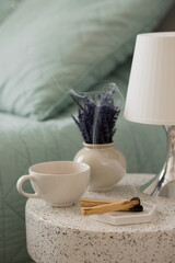 Peruvian palo santo holy wood smoke smolders on the table whith lavender flowers and a candle near the bed. Aromatherapy and relaxing.
